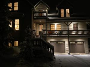Una casa de noche con sus puertas de garaje iluminadas en 5 BR Large Home - Walk to Main St - 2 Master Suites, en Park City