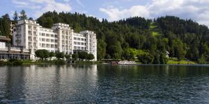 a large building next to a large body of water at Grand Hotel Toplice - Small Luxury Hotels of the World in Bled