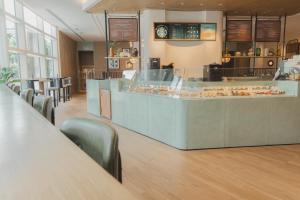a bakery with a counter and chairs in a room at Centara Grand at CentralWorld in Bangkok