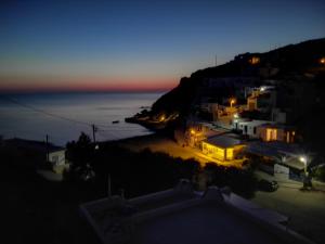 a view of a town at night with the ocean at Perigiali Rooms & Apartments Folegandros in Agali