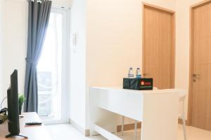 a room with a desk with a computer and a window at Cozy and Enjoy Living 2BR at Tokyo Riverside PIK 2 Apartment By Travelio in Rawalembang