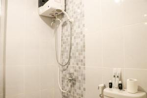 a shower in a bathroom with a shower head at Cozy and Enjoy Living 2BR at Tokyo Riverside PIK 2 Apartment By Travelio in Rawalembang +15 photos