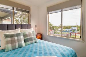 a bedroom with a bed with a view of the ocean at Tides & Tails - Pet Friendly in Scamander