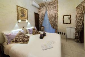 a bedroom with a large white bed with pillows at B&B Roma Royal Residence in Rome