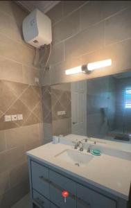 un baño con lavabo y espejo en Tranquil Haven Villa, en Kumasi 9 fotos más