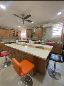 una cocina con una isla grande con 2 taburetes en Tranquil Haven Villa, en Kumasi