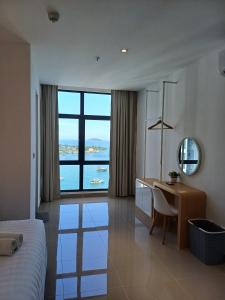 a bedroom with a desk and a bed with a view at The Shore Cozy Suite in CBD in Kota Kinabalu