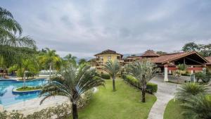 ein Bild eines Resorts mit einem Pool und Palmen in der Unterkunft Belíssimo Duplex no Resort Costabella em Angra dos Reis in Angra dos Reis