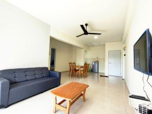 a living room with a couch and a tv at Sunshine Bay Resort by NG in Port Dickson