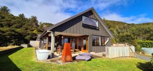a small house with a toilet on the grass at Tawa Whare holiday accommodation in Raglan