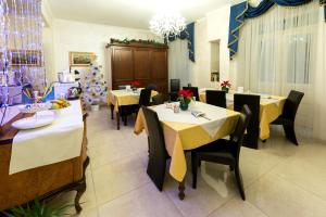 a restaurant with tables and chairs and a chandelier at B&B Roma Royal Residence in Rome