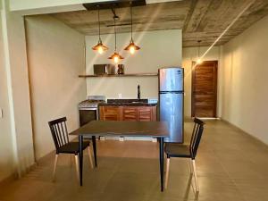a kitchen with a table with chairs and a refrigerator at Lolitas Suites 303 in Zihuatanejo +16 photos