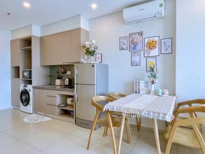 a kitchen with a table and chairs and a refrigerator at PƠ Homestay THESONG Vũng Tàu in Vung Tau
