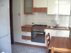 a kitchen with a stove and a sink and a table at Jean Home in Gallarate