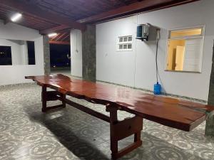 a large wooden bench in a room with a wall at Praia das Dunas SE in Estância