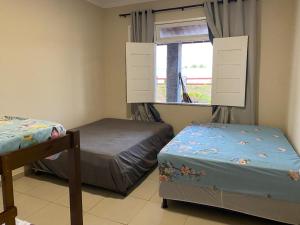 two beds in a room with a window at Praia das Dunas SE in Estância +21 photos