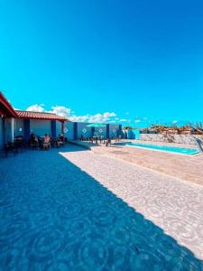 a resort with a swimming pool and the ocean at Praia das Dunas SE in Estância