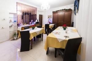 a dining room with tables and chairs with yellow table cloth at B&B Roma Royal Residence in Rome
