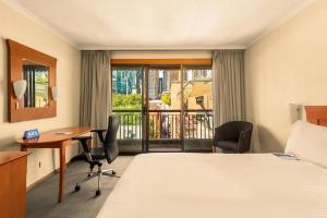 シドニーにあるSydney Harbour Hotelのベッドと机と窓があるホテルの部屋 +34枚の写真