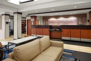 a lobby with a couch and a bar at Fairfield Inn & Suites Bedford in Bedford