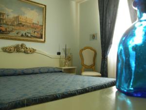 una camera con un letto e un vaso blu su un tavolo di Residence Meuble' Cortina a Quinto di Treviso