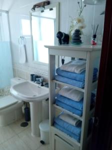 łazienka z umywalką i półką z ręcznikami w obiekcie Casa San Miguel free WiFi w mieście Morro del Jable