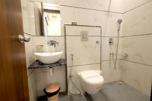 a bathroom with a toilet and a sink and a shower at Hotel Shrinath Palace in Mathura