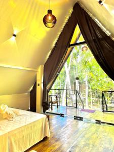 una camera con un letto e una grande finestra di Rustic Cottages Udawalawe a Udawalawe