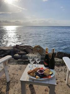 a table with a plate of food and wine glasses at Belle's on Ballow - Kookaburra Lodge - Absolute Waterfront in Amity Point