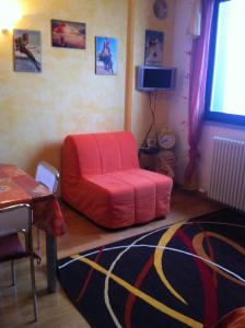 a living room with a red chair and a table at Torre Dell'orologio Apartment in Sestriere