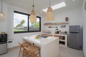 a kitchen with a white counter and a refrigerator at Villa Sawahku - 2 Bedrooms Private Villa with Rooftop and View in Canggu