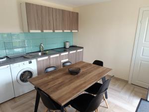 a kitchen with a wooden table and a washing machine at Draugu māja in Krāslava