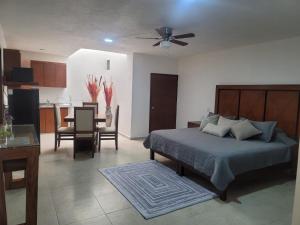 a bedroom with a bed and a kitchen with a table at Auroras in Lagos de Moreno