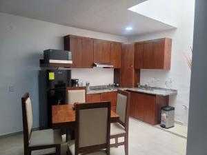 a kitchen with wooden cabinets and a table and chairs at Auroras in Lagos de Moreno +26 photos