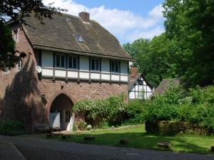 an old brick house with an archway in a yard at Holiday home Keim Comfortable Vacation Home in Negenborn