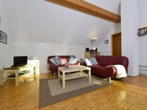 a living room with a red couch and a table at Holiday home Keim Comfortable Vacation Home in Negenborn