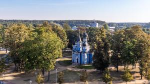 a blue building in the middle of a park with trees at DRUSKININKŲ PANORAMA Apartamentai in Druskininkai