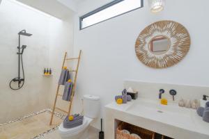 a bathroom with a toilet and a mirror at Villa Sawahku - 2BR Private Villa with Rooftop & Rice Field View in Canggu