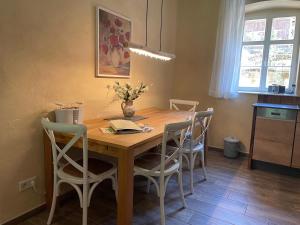 a dining room table with chairs and a vase on it at Ferienwohnung Parkblick im Badehaus in Schweizermühle +13 photos