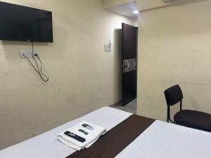 a room with a bed and a tv on the wall at Hotel Vaithi Residency - Andheri West in Mumbai