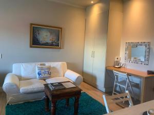 a living room with a couch and a table at Hermanus Waterfront Apartment 12 in Hermanus
