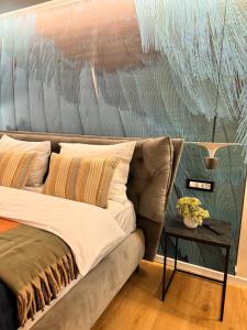 a bed in a room with a painting on the wall at Ylly aparts in Braşov