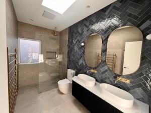 a bathroom with two sinks and a large mirror at Royadie Resort - Pool Spa Tennis 500m to beach in Blairgowrie