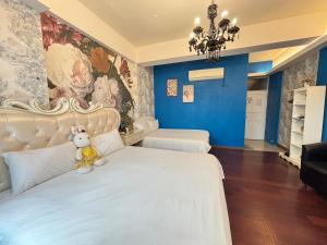 a bedroom with a white bed with a stuffed animal on it at 五指山遠百民宿-免費停車場-6人家庭房附電動麻將桌 in Hualien City