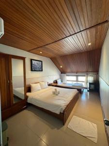 a bedroom with a large bed with a wooden ceiling at Bed Station Hostel & Pool Bar Hội An " Former Sunflower" in Hoi An