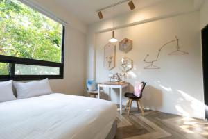 una camera da letto con un letto, una scrivania e una finestra di Yes Yes I Am Willing a Tainan Altre 37 foto