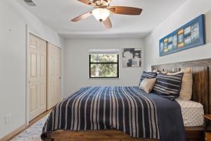 a bedroom with a bed with a ceiling fan at Peaceful Creekside Buddha Retreat in Groveland