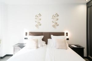 a bedroom with a large white bed with white pillows at Apartamentos GO La Circular-Parking Gratuito - Zona libre de bajas emisiones in Valladolid