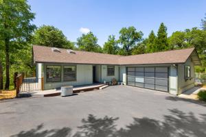 a house with a driveway and a garage at Peaceful Creekside Buddha Retreat in Groveland