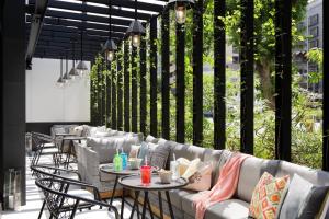 a patio with tables and couches and chairs at Moxy Osaka Umeda in Osaka